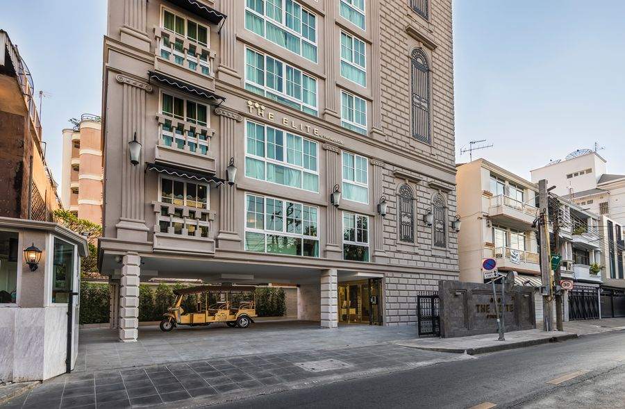 The French classical facade of The Elite at Thong Lor 25, with mint casements and scalloped awnings, seen from Soi Saeng Ngoen off Sukhumvit 55 in Bangkok