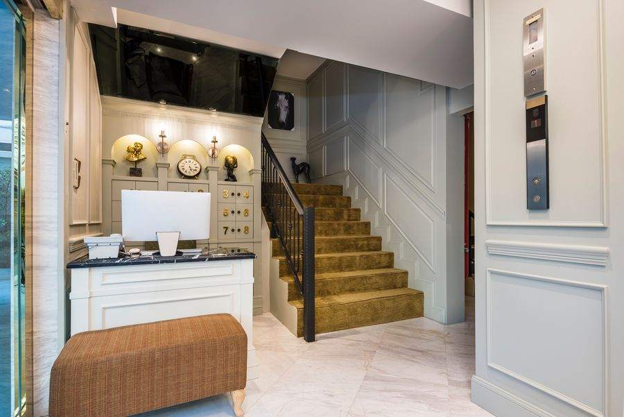 The reception desk at The Elite Thong Lor 25, below pale panelled cupboard doors carrying large applied gold numerals